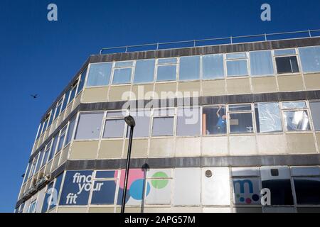 Wenn ein Vogel über den Kopf fliegt, streckt sich ein Arbeiter in die Ecke eines Fensters eines lokalen Fitnessstudios, am 21. Januar 2020, in Croydon, London, England. Stockfoto