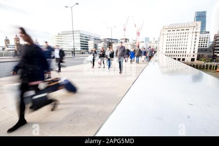 Londoner Hauptverkehrszeit. Pendler und Büroangestellte, die während ihrer Hauptverkehrszeit die London Bridge überqueren, pendeln. Stockfoto