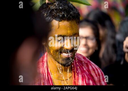 Indischer bengalischer Bräutigam im Lächeln mit bengalischer Bräutigam und Kopfband und mit Dhoti und weißem Kleid Stockfoto