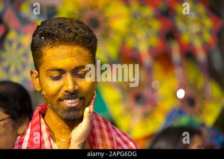 Indischer bengalischer Bräutigam im Lächeln mit bengalischer Bräutigam und Kopfband und mit Dhoti und weißem Kleid Stockfoto