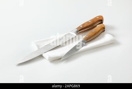 Küchenmesser und Trennmesser auf weißer Serviette Stockfoto