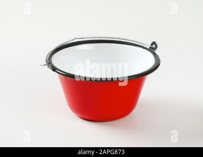 Roter Emaillekessel/Kochtopf, der zum Kochen im Freien über einem offenen Feuer verwendet wird und Gulasch, Suppen, Soßen, Glühwein, Dips, Käsefondue serviert Stockfoto