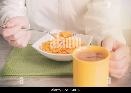 Frau isst gesundes Frühstück aus Cornflakes mit Milch Stockfoto