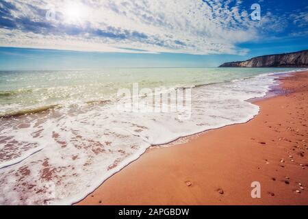 Fantastischer Blick auf das azurblaue Meer und den gelben Sand. Klarer Himmel an einem sonnigen Tag mit flauschigen Wolken. Malerische und wunderschöne Szene. Stockfoto