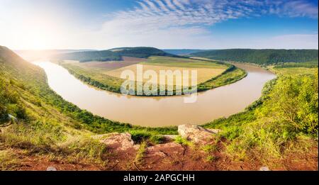 Sinuöser Fluss, der im Sonnenlicht durch den Canyon fließt. Dramatische und malerische Szene. Ort Ort Dnister. Ukraine, Europa. Beauty-Welt. Stockfoto