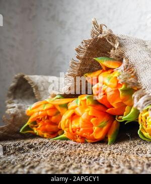 Schöne orange Tulpen mit einem leinen Servietten Stockfoto