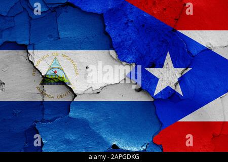 Flaggen von Nicaragua und Puerto Rico auf gerissene Wand gemalt Stockfoto