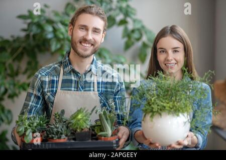 Mann und Frau halten verschiedene Pflanzen in Händen Stockfoto