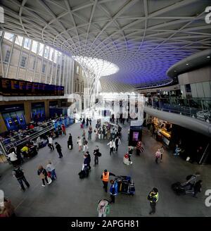 London, GROSSBRITANNIEN - 26. Mai 2013: Passagiere, die auf Bordinformationen über das Concourse in King's Cross Station, London warten. GROSSBRITANNIEN Stockfoto