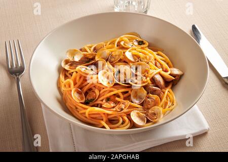 Eine Schüssel mit Spaghetti alle Vongole oder frischen Clams aus der Region Kampanien in Italien für einen köstlichen Fisch- und Meeresfrüchte-Vorspeisen, der am Tisch serviert wird Stockfoto