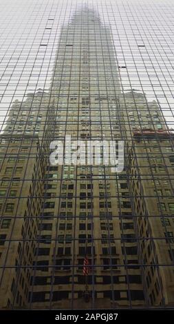 Spiegelung des Chrysler Building im Grand Hyatt Hotel an der Lexington Avenue mit sichtbaren Sternen und Streifen Stockfoto