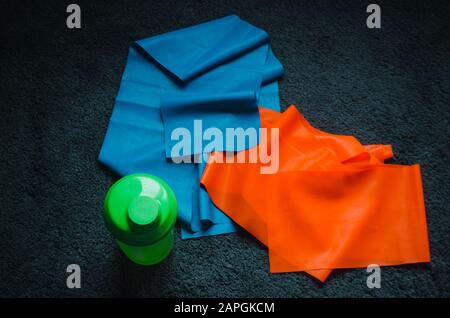 Über dem Kopf Schuss einer Wasserflasche in der Nähe eines blauen und Roter Gummi auf dem Boden Stockfoto