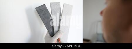 Männliche Builder in Weiß Schutzhandschuhe halten Grau Stockfoto