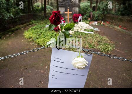 Hamburg, Deutschland. Januar 2020. Blumen liegen auf dem Grab des Schauspielers Jan Fedder auf dem Ohlsdorfer Friedhof. Davor hängt eine Kette mit einem Schild, das sagt: "Ich schlafe. Bitte nicht stören. Lassen Sie Ihre Blumen und Kerzen vorne. Das Zimmer vor dem Mahnmal ist mein Zimmer, nicht betreten!! Ta! Dein Jan'. Um die Pflanzen und den Rasen auf dem Grab des Schauspielers zu schützen, haben Friedhofsmitarbeiter eine Kette vor die Ruhestätte gelegt. (Zu dpa "Zerwürfnis am Fedder Grab - Friedhof legt Zeichen und Kette") Credit: Daniel Bockwoldt / dpa / Alamy Live News Stockfoto