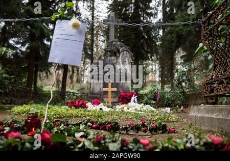 Hamburg, Deutschland. Januar 2020. Blumen liegen auf dem Grab des Schauspielers Jan Fedder auf dem Ohlsdorfer Friedhof. Davor hängt eine Kette mit einem Schild, das sagt: "Ich schlafe. Bitte nicht stören. Lassen Sie Ihre Blumen und Kerzen vorne. Das Zimmer vor dem Mahnmal ist mein Zimmer, nicht betreten!! Ta! Dein Jan'. Um die Pflanzen und den Rasen auf dem Grab des Schauspielers zu schützen, haben Friedhofsmitarbeiter eine Kette vor die Ruhestätte gelegt. (Zu dpa "Zerwürfnis am Fedder Grab - Friedhof legt Zeichen und Kette") Credit: Daniel Bockwoldt / dpa / Alamy Live News Stockfoto