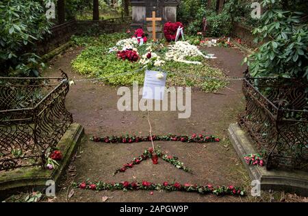 Hamburg, Deutschland. Januar 2020. Blumen liegen auf dem Grab des Schauspielers Jan Fedder auf dem Ohlsdorfer Friedhof. Davor hängt eine Kette mit einem Schild, das sagt: "Ich schlafe. Bitte nicht stören. Lassen Sie Ihre Blumen und Kerzen vorne. Das Zimmer vor dem Mahnmal ist mein Zimmer, nicht betreten!! Ta! Dein Jan'. Um die Pflanzen und den Rasen auf dem Grab des Schauspielers zu schützen, haben Friedhofsmitarbeiter eine Kette vor die Ruhestätte gelegt. (Zu dpa "Zerwürfnis am Fedder Grab - Friedhof legt Zeichen und Kette") Credit: Daniel Bockwoldt / dpa / Alamy Live News Stockfoto