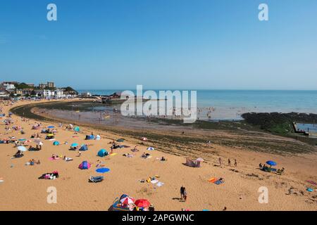 Menschen sonnen sich und Kinder spielen am Strand, natürliches Meerespool in den Felsen an der Viking Bay, Broadstairs, Kent, Großbritannien Stockfoto