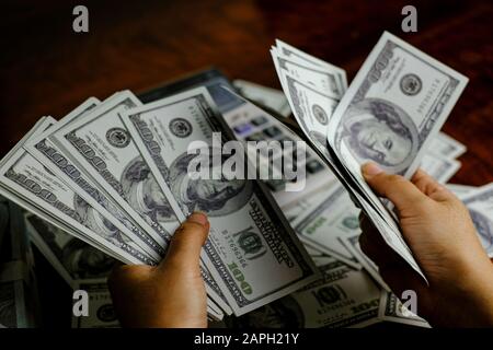 Unternehmer Frauen zählen Geld auf einem Stapel von 100 US-Dollar Banknoten Stockfoto