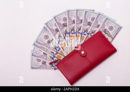 Amerikanische Hundert-Dollar-Währung, Banknoten in der roten Geldbörse. Reichtum, Geld sparen, reichlich. Leerzeichen für Text auf weißem Hintergrund. Stockfoto