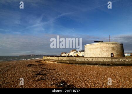 Martello Tower Nummer 74und Gebäude am Meer an einem Winternachmittag, Seaford, East Sussex, England Stockfoto