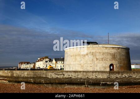 Martello Tower Nummer 74und Gebäude am Meer an einem Winternachmittag, Seaford, East Sussex, England Stockfoto