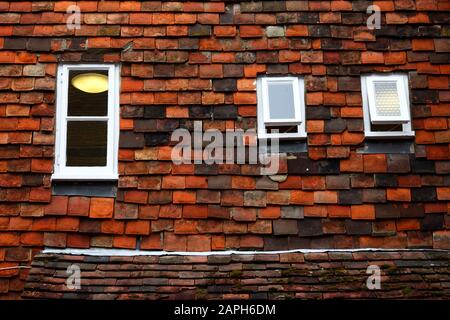 Details zu kleinen Fenstern, die in senkrechte Fliesen (eine typische Bautechnik von Weald of Kent) an der Wand, Tenterden, Kent, England, gesetzt sind Stockfoto