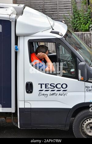 Straße. Szene Nahaufnahme des Tesco Supermarkt Home food supply chain Anlieferung Treiber Mann kommt früh & wartet in Van für seinen Kunden Essex England Großbritannien Stockfoto