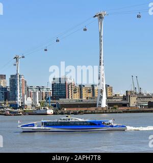TFL thames Clipper Kataman Riverbus, der unterhalb der Emirates Air Line Cable Car-Verbindung von der Greenwich Peninsula zum Royal Victoria Dock London England UK vorbeiführt Stockfoto