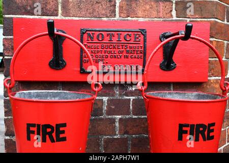 Nahaufnahme der Feuereimer an der Wand des Stationsgebäudes, Bahnhof Tenterden Town, Kent & East Sussex Railway, Kent, England Stockfoto