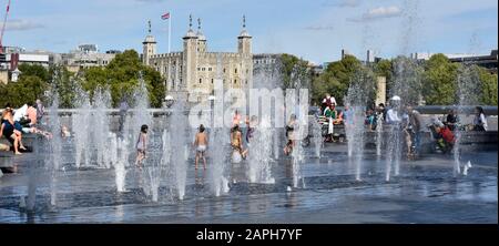 Heiße Sommer-Kinder spielen in öffentlichen Wasserfontänen unterschiedlicher Höhe in mehr London neben dem Thames Tower of London jenseits von Southwark England Großbritannien Stockfoto