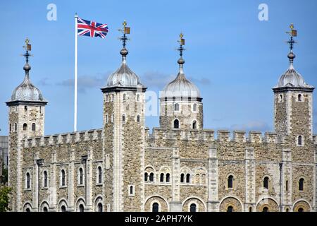 Nahaufnahme der Steinmauer und des Dachturms des berühmten historischen White Tower-Gebäudes im Tower of London Castle Union Jack Flag & Weather Vane England UK Stockfoto