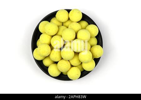 Schale voller gelber Boilies, Angelbait für Karpfen, isoliert auf weißem Grund. Hochauflösendes Foto. Volle Schärfentiefe. Stockfoto