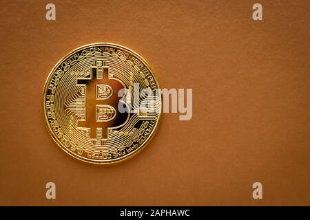 Eine goldene Bitcoin auf braunem Grund. E-Commerce, Kryptokurrency. Blockchain, internationaler Bergbau. Stockfoto