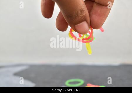 Mehrfarbige Gummibänder von Hand. Gummibänder und Finger. Gummibänder aus der Hand geworfen. Stockfoto