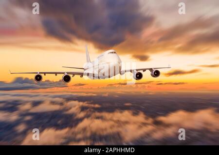 Kommerzielle Flugzeuge fliegen über Wolken in dramatischem Sonnenaufgang Licht über der Stadt Stockfoto