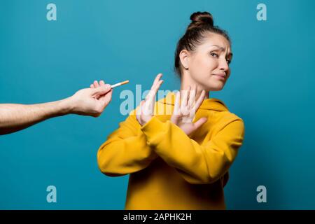 Mädchen lehnt eine Zigarette ab, die eine männliche Hand ihr vorhält, ganz aus der Nähe Stockfoto