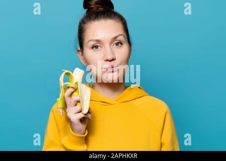 Mädchen isst Banane mit Vergnügen, Nahaufnahme Stockfoto