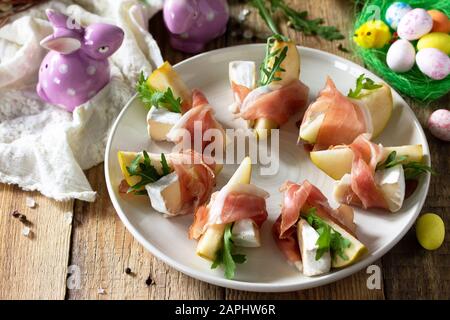 Festliche Snacks. Birnen-Vorspeise mit Jamon, Arugula und brie-käse auf einem rustikalen Holztisch. Stockfoto