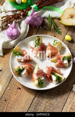 Festliche Snacks. Birnen-Vorspeise mit Jamon, Arugula und brie-käse auf einem rustikalen Holztisch. Kopierbereich. Stockfoto