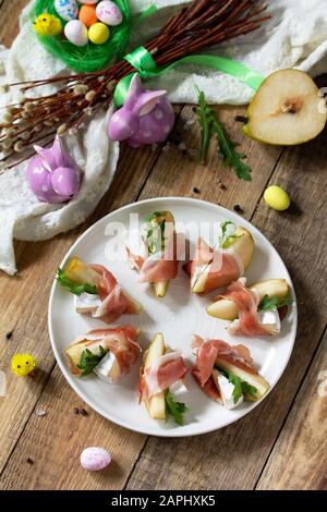 Festliche Snacks. Birnen-Vorspeise mit Jamon, Arugula und brie-käse auf einem rustikalen Holztisch. Stockfoto