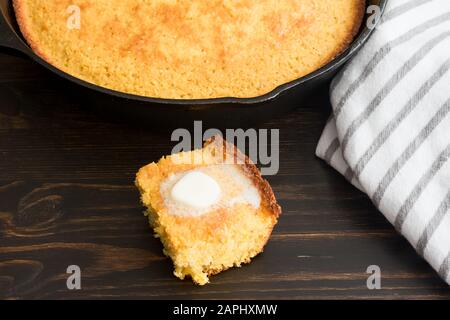Buttermilch Cornbread mit Butter: Ein Stück traditionelles Südliches Cornbrot mit einem Klaps schmelzender Butter Stockfoto