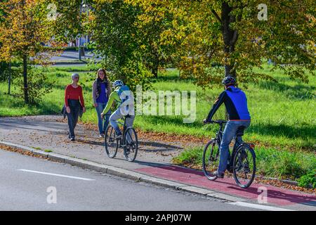 Radfahrer vom Radweg nach einem kombinierten Radfahren Straße und Fußweg mit Fußgängern Stockfoto