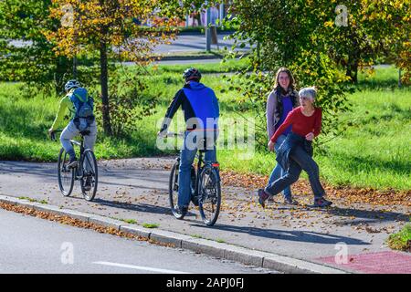 Radfahrer vom Radweg nach einem kombinierten Radfahren Straße und Fußweg mit Fußgängern Stockfoto