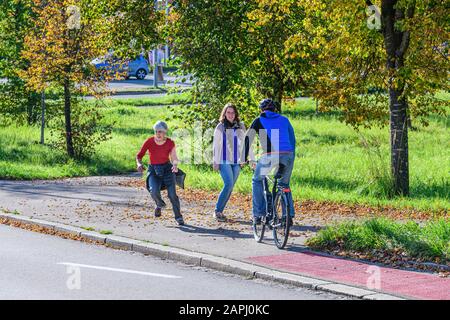 Radfahrer vom Radweg nach einem kombinierten Radfahren Straße und Fußweg mit Fußgängern Stockfoto