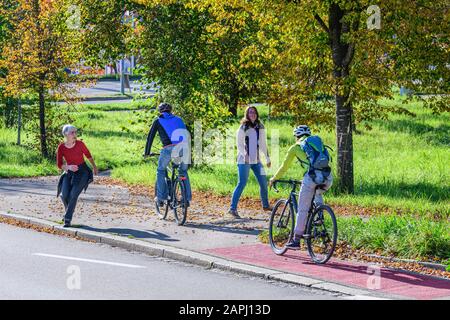 Radfahrer vom Radweg nach einem kombinierten Radfahren Straße und Fußweg mit Fußgängern Stockfoto