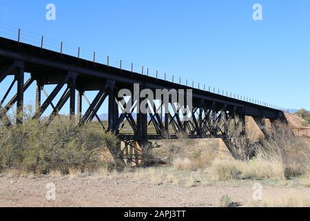 Eine Eisenbahnbrücke in der Wüste mit Flussübergang darunter Stockfoto