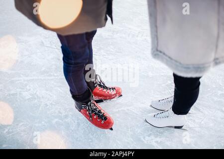 Skates Guy und Mädchen für einen Spaziergang auf der Eisbahn im Winter, Bokeh-Hintergrund, Draufsicht Stockfoto