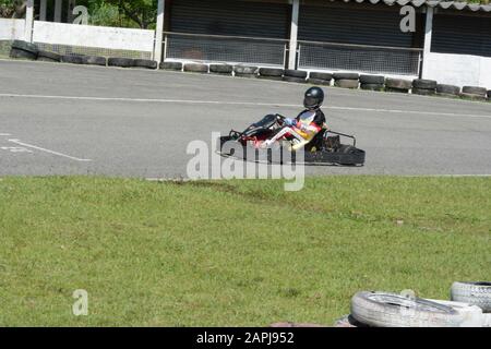 Florianopolis - Brasilien, 9. Februar 2019: Seitenansicht des Gokart-Fahrers, der an sonnigen Tagen auf der Rennstrecke fährt. Kartsport ist ein Motorsport, der in vielen Sportarten praktiziert wird Stockfoto