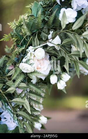 Wunderschöne weiße Blumen auf einem metallenen Hochzeitsbogen für die Hochzeit im Freien Stockfoto