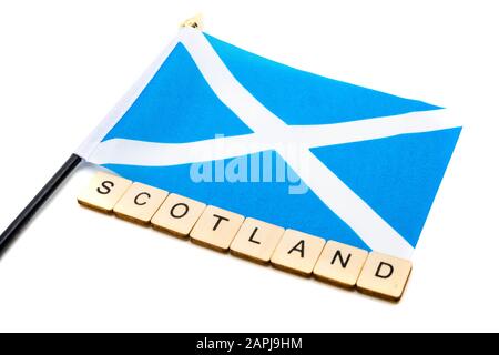 Die Nationalflaggen Schottlands, der Saltaire oder das Kreuz von St Andrews auf weißem Hintergrund mit einem Schild, das Schottland liest Stockfoto